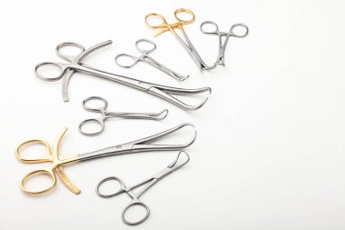 Çelik cerrahi aletler ve laboratuvar ekipmanları beyaz arka planda izole edilmiş. Profesyonel klinik aletleri. Tıbbi, cerrahi, ambulans ve veteriner konsepti. Yumuşak seçici odaklı yakın plan