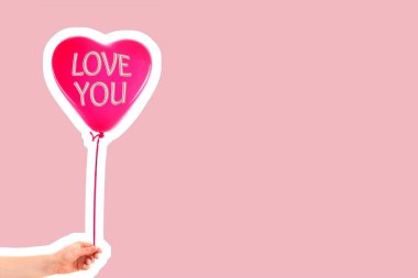 Kadın eli kırmızı kauçuk, şişme kalp şeklinde balon tutuyor. Aşk, ilişki, sevgililer günü ve doğum günü kutlaması konsepti. Boş kopya alanı olan dergi tarzı moda kolajı