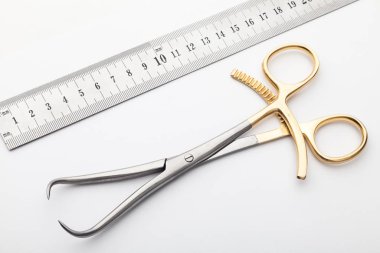 Çelik cerrahi aletler ve laboratuvar ekipmanları beyaz arka planda izole edilmiş. Profesyonel klinik aletleri. Tıbbi, cerrahi, ambulans ve veteriner konsepti. Yumuşak seçici odaklı yakın plan