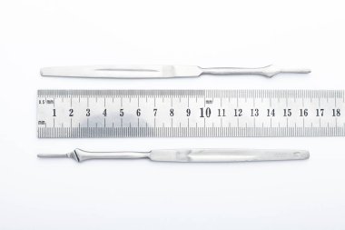 Çelik cerrahi aletler ve laboratuvar ekipmanları beyaz arka planda izole edilmiş. Profesyonel klinik aletleri. Tıbbi, cerrahi, ambulans ve veteriner konsepti. Yumuşak seçici odaklı yakın plan