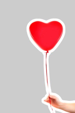 Kadın eli kırmızı kauçuk, şişme kalp şeklinde balon tutuyor. Aşk, ilişki, sevgililer günü ve doğum günü kutlaması konsepti. Boş kopya alanı olan dergi tarzı moda kolajı