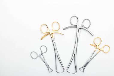 Çelik cerrahi aletler ve laboratuvar ekipmanları beyaz arka planda izole edilmiş. Profesyonel klinik aletleri. Tıbbi, cerrahi, ambulans ve veteriner konsepti. Yumuşak seçici odaklı yakın plan