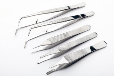 Çelik cerrahi aletler ve laboratuvar ekipmanları beyaz arka planda izole edilmiş. Profesyonel klinik aletleri. Tıbbi, cerrahi, ambulans ve veteriner konsepti. Yumuşak seçici odaklı yakın plan