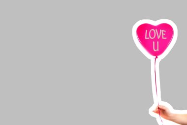 Kadın eli kırmızı kauçuk, şişme kalp şeklinde balon tutuyor. Aşk, ilişki, sevgililer günü ve doğum günü kutlaması konsepti. Boş kopya alanı olan dergi tarzı moda kolajı