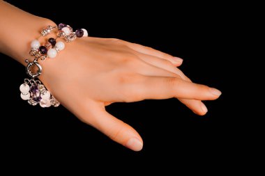 Güzel bir el yapımı mücevher bileziği. Renkli parlak boncuklar ve nötr manikürlü gevşek bir kadın bileği. Moda ve el işi aksesuarları. Yumuşak seçici odaklı yakın plan