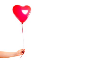 Kadın eli kırmızı kauçuk, şişme kalp şeklinde balon tutuyor. Aşk, ilişki, sevgililer günü ve doğum günü kutlaması konsepti. Stüdyo görüntüsü boş kopya alanı olan bulanık bir arkaplan üzerinde
