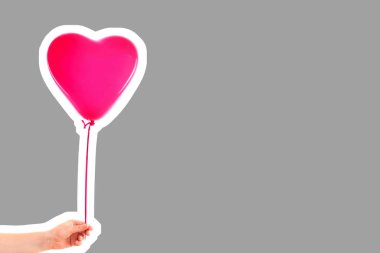 Kadın eli pembe kauçuk, şişme kalp şeklinde balon tutuyor. Aşk, ilişki, sevgililer günü ve doğum günü kutlaması konsepti. Boş kopya alanı olan dergi tarzı moda kolajı