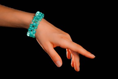 Güzel bir el yapımı mücevher bileziği. Renkli parlak boncuklar ve nötr manikürlü gevşek bir kadın bileği. Moda ve el işi aksesuarları. Yumuşak seçici odaklı yakın plan