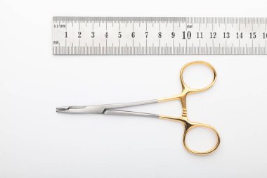 Çelik cerrahi aletler ve laboratuvar ekipmanları beyaz arka planda izole edilmiş. Profesyonel klinik aletleri. Tıbbi, cerrahi, ambulans ve veteriner konsepti. Yumuşak seçici odaklı yakın plan