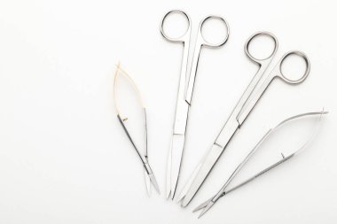 Çelik cerrahi aletler ve laboratuvar ekipmanları beyaz arka planda izole edilmiş. Profesyonel klinik aletleri. Tıbbi, cerrahi, ambulans ve veteriner konsepti. Yumuşak seçici odaklı yakın plan