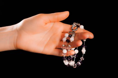 Güzel bir el yapımı mücevher bileziği. Renkli parlak boncuklar ve nötr manikürlü gevşek bir kadın bileği. Moda ve el işi aksesuarları. Yumuşak seçici odaklı yakın plan