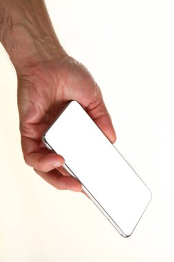 İnsan eli, avucunda boş bir krom ekran olan modern bir akıllı telefonu tutar. Teknoloji ve reklam kavramı. Ayrıntılı yakın çekim stüdyo çekimi soyut beyaz arka planda izole