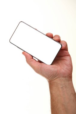 İnsan eli, avucunda boş bir krom ekran olan modern bir akıllı telefonu tutar. Teknoloji ve reklam kavramı. Ayrıntılı yakın çekim stüdyo çekimi soyut beyaz arka planda izole