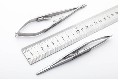 Çelik cerrahi aletler ve laboratuvar ekipmanları beyaz arka planda izole edilmiş. Profesyonel klinik aletleri. Tıbbi, cerrahi, ambulans ve veteriner konsepti. Yumuşak seçici odaklı yakın plan