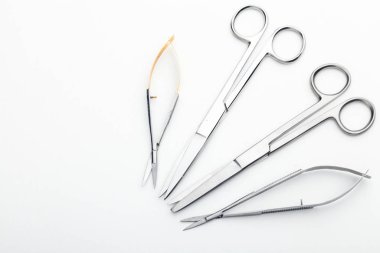 Çelik cerrahi aletler ve laboratuvar ekipmanları beyaz arka planda izole edilmiş. Profesyonel klinik aletleri. Tıbbi, cerrahi, ambulans ve veteriner konsepti. Yumuşak seçici odaklı yakın plan