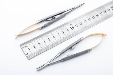 Çelik cerrahi aletler ve laboratuvar ekipmanları beyaz arka planda izole edilmiş. Profesyonel klinik aletleri. Tıbbi, cerrahi, ambulans ve veteriner konsepti. Yumuşak seçici odaklı yakın plan