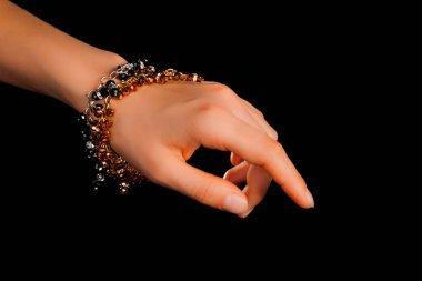 Güzel bir el yapımı mücevher bileziği. Renkli parlak boncuklar ve nötr manikürlü gevşek bir kadın bileği. Moda ve el işi aksesuarları. Yumuşak seçici odaklı yakın plan