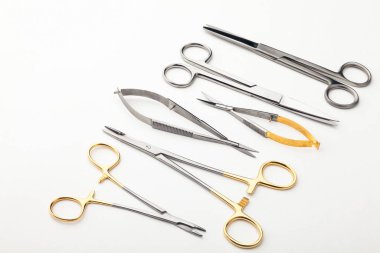 Çelik cerrahi aletler ve laboratuvar ekipmanları beyaz arka planda izole edilmiş. Profesyonel klinik aletleri. Tıbbi, cerrahi, ambulans ve veteriner konsepti. Yumuşak seçici odaklı yakın plan