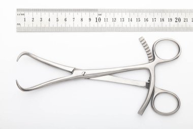 Çelik cerrahi aletler ve laboratuvar ekipmanları beyaz arka planda izole edilmiş. Profesyonel klinik aletleri. Tıbbi, cerrahi, ambulans ve veteriner konsepti. Yumuşak seçici odaklı yakın plan