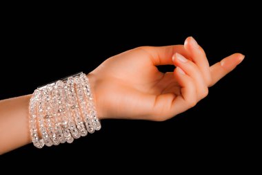 Güzel bir el yapımı mücevher bileziği. Renkli parlak boncuklar ve nötr manikürlü gevşek bir kadın bileği. Moda ve el işi aksesuarları. Yumuşak seçici odaklı yakın plan