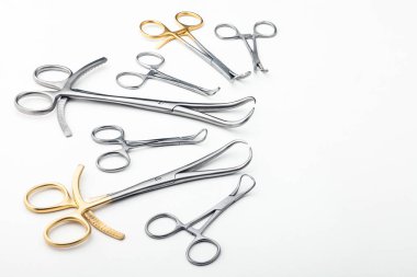 Çelik cerrahi aletler ve laboratuvar ekipmanları beyaz arka planda izole edilmiş. Profesyonel klinik aletleri. Tıbbi, cerrahi, ambulans ve veteriner konsepti. Yumuşak seçici odaklı yakın plan