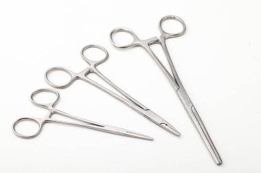 Çelik cerrahi aletler ve laboratuvar ekipmanları beyaz arka planda izole edilmiş. Profesyonel klinik aletleri. Tıbbi, cerrahi, ambulans ve veteriner konsepti. Yumuşak seçici odaklı yakın plan