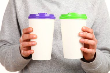 İnsan eli plastik kapaklı boş bir kahve fincanı tutar. Tek kullanımlık fincana çay ya da kahve konsepti. Metin veya logo için yeri ve yeri kopyala. Beyaz bir arkaplanda izole edilmiş