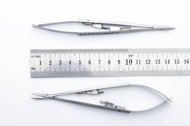 Çelik cerrahi aletler ve laboratuvar ekipmanları beyaz arka planda izole edilmiş. Profesyonel klinik aletleri. Tıbbi, cerrahi, ambulans ve veteriner konsepti. Yumuşak seçici odaklı yakın plan