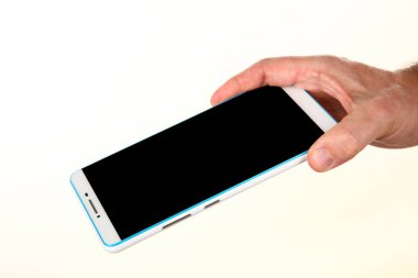 İnsan eli, avucunda boş bir krom ekran olan modern bir akıllı telefonu tutar. Teknoloji ve reklam kavramı. Ayrıntılı yakın çekim stüdyo çekimi soyut beyaz arka planda izole
