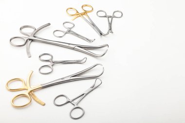 Çelik cerrahi aletler ve laboratuvar ekipmanları beyaz arka planda izole edilmiş. Profesyonel klinik aletleri. Tıbbi, cerrahi, ambulans ve veteriner konsepti. Yumuşak seçici odaklı yakın plan