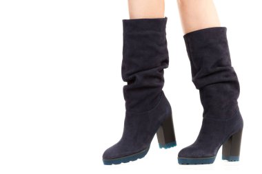 Bayan giysi ayakkabısı. Uzun ince dişinin bacakları yüksek topuklu uzun çizmeler giyer. Fotokopi alanı olan moda modeli. Klasik ve günlük kıyafet konsepti. Ayrıntılı yakın çekim stüdyo çekimi beyaz arkaplanda izole edildi