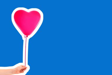 Kadın eli pembe kauçuk, şişme kalp şeklinde balon tutuyor. Aşk, ilişki, sevgililer günü ve doğum günü kutlaması konsepti. Boş kopya alanı olan dergi tarzı moda kolajı
