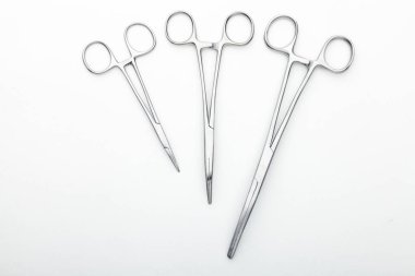 Çelik cerrahi aletler ve laboratuvar ekipmanları beyaz arka planda izole edilmiş. Profesyonel klinik aletleri. Tıbbi, cerrahi, ambulans ve veteriner konsepti. Yumuşak seçici odaklı yakın plan