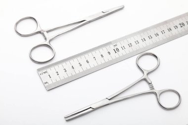 Çelik cerrahi aletler ve laboratuvar ekipmanları beyaz arka planda izole edilmiş. Profesyonel klinik aletleri. Tıbbi, cerrahi, ambulans ve veteriner konsepti. Yumuşak seçici odaklı yakın plan