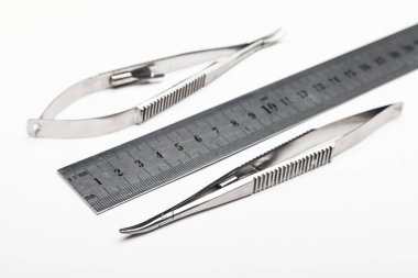 Çelik cerrahi aletler ve laboratuvar ekipmanları beyaz arka planda izole edilmiş. Profesyonel klinik aletleri. Tıbbi, cerrahi, ambulans ve veteriner konsepti. Yumuşak seçici odaklı yakın plan