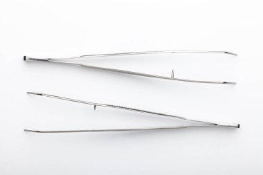 Çelik cerrahi aletler ve laboratuvar ekipmanları beyaz arka planda izole edilmiş. Profesyonel klinik aletleri. Tıbbi, cerrahi, ambulans ve veteriner konsepti. Yumuşak seçici odaklı yakın plan