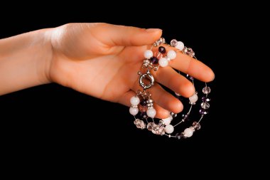 Güzel bir el yapımı mücevher bileziği. Renkli parlak boncuklar ve nötr manikürlü gevşek bir kadın bileği. Moda ve el işi aksesuarları. Yumuşak seçici odaklı yakın plan