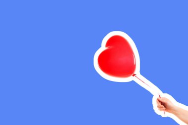 Kadın eli kırmızı kauçuk, şişme kalp şeklinde balon tutuyor. Aşk, ilişki, sevgililer günü ve doğum günü kutlaması konsepti. Boş kopya alanı olan dergi tarzı moda kolajı