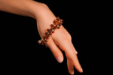 Güzel bir el yapımı mücevher bileziği. Renkli parlak boncuklar ve nötr manikürlü gevşek bir kadın bileği. Moda ve el işi aksesuarları. Yumuşak seçici odaklı yakın plan