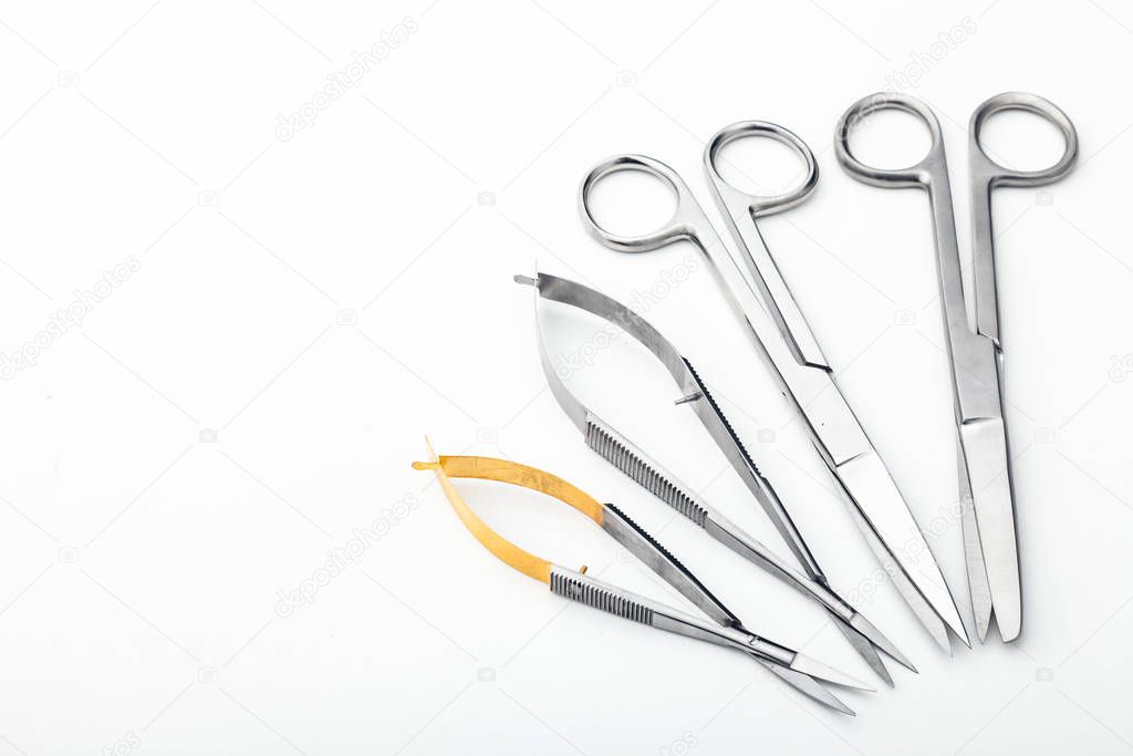 Steel surgical tools and laboratory equipment isolated on a white background. Professional clinic instruments. Medical, surgery, ambulance and veterinarian concept. Closeup with soft selective focus