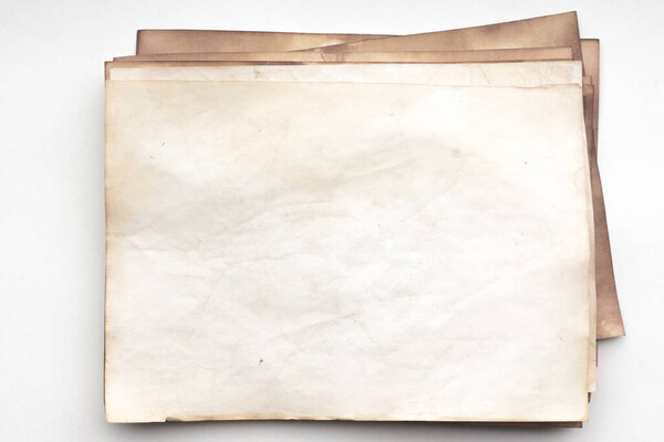 Aged paper sheet. Blank old background with dust and dirty stains. Vintage and antique art concept. Detailed closeup studio shot. Front view. Toned