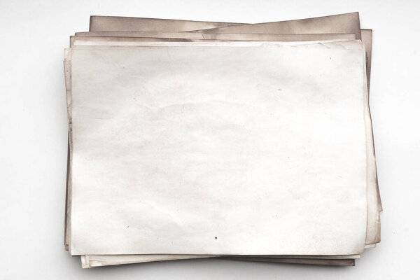 Aged paper sheet. Blank old background with dust and dirty stains. Vintage and antique art concept. Detailed closeup studio shot. Front view. Toned