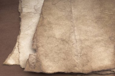 Aged paper sheet. Blank old background with dust and dirty stains. Vintage and antique art concept. Poster mockup. Detailed closeup studio shot. Front view. Toned