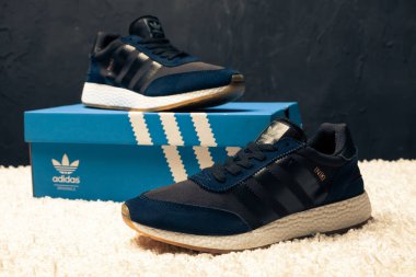 Yeni renkli ve güzel Adidas Iniki koşu ayakkabıları, spor ayakkabıları, spor ayakkabıları, spor ayakkabıları soyut arka planda bir marka kutusu olan logoyu gösteriyor. Spor ve günlük ayakkabı konsepti. Kyiv, Ukrayna-7 Mart 2018