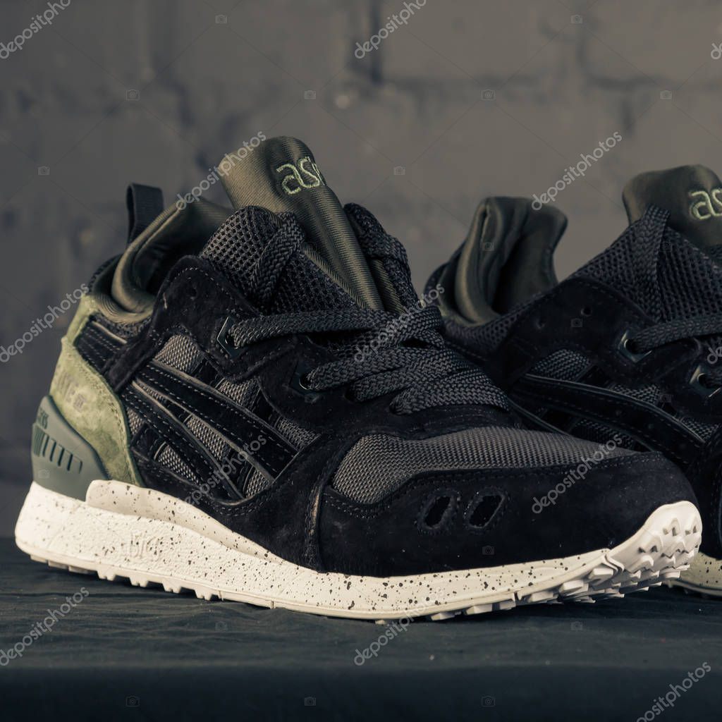 New beautiful colorful and nice Asics running shoes, sneakers, trainers shows logo with a brand box on abstract background. Sport and casual footwear concept. Kyiv, Ukraine-November 16, 2017