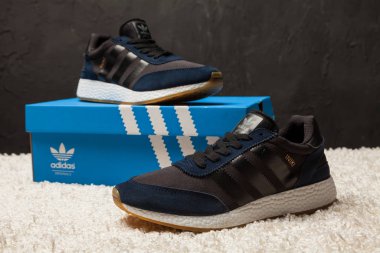 Yeni renkli ve güzel Adidas Iniki koşu ayakkabıları, spor ayakkabıları, spor ayakkabıları, spor ayakkabıları soyut arka planda bir marka kutusu olan logoyu gösteriyor. Spor ve günlük ayakkabı konsepti. Kyiv, Ukrayna-7 Mart 2018