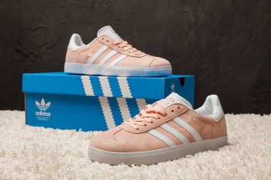 Yeni renkli ve güzel Adidas Gazelle koşu ayakkabıları, spor ayakkabıları, spor ayakkabıları, spor ayakkabıları soyut arka planda bir marka kutusu olan logoyu gösteriyor. Spor ve günlük ayakkabı konsepti. Kyiv, Ukrayna-22 Nisan 2018