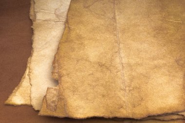 Aged paper sheet. Blank old background with dust and dirty stains. Vintage and antique art concept. Poster mockup. Detailed closeup studio shot. Front view. Toned