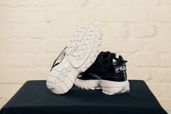 Yeni renkli ve güzel Fila Disruptor koşu ayakkabıları, spor ayakkabıları, spor ayakkabıları, spor ayakkabıları soyut arka planda bir marka kutusu olan logoyu gösteriyor. Spor ve günlük ayakkabı konsepti. Kyiv, Ukrayna - 28 Ocak 2018