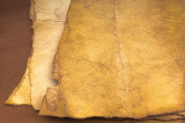 Aged paper sheet. Blank old background with dust and dirty stains. Vintage and antique art concept. Poster mockup. Detailed closeup studio shot. Front view. Toned